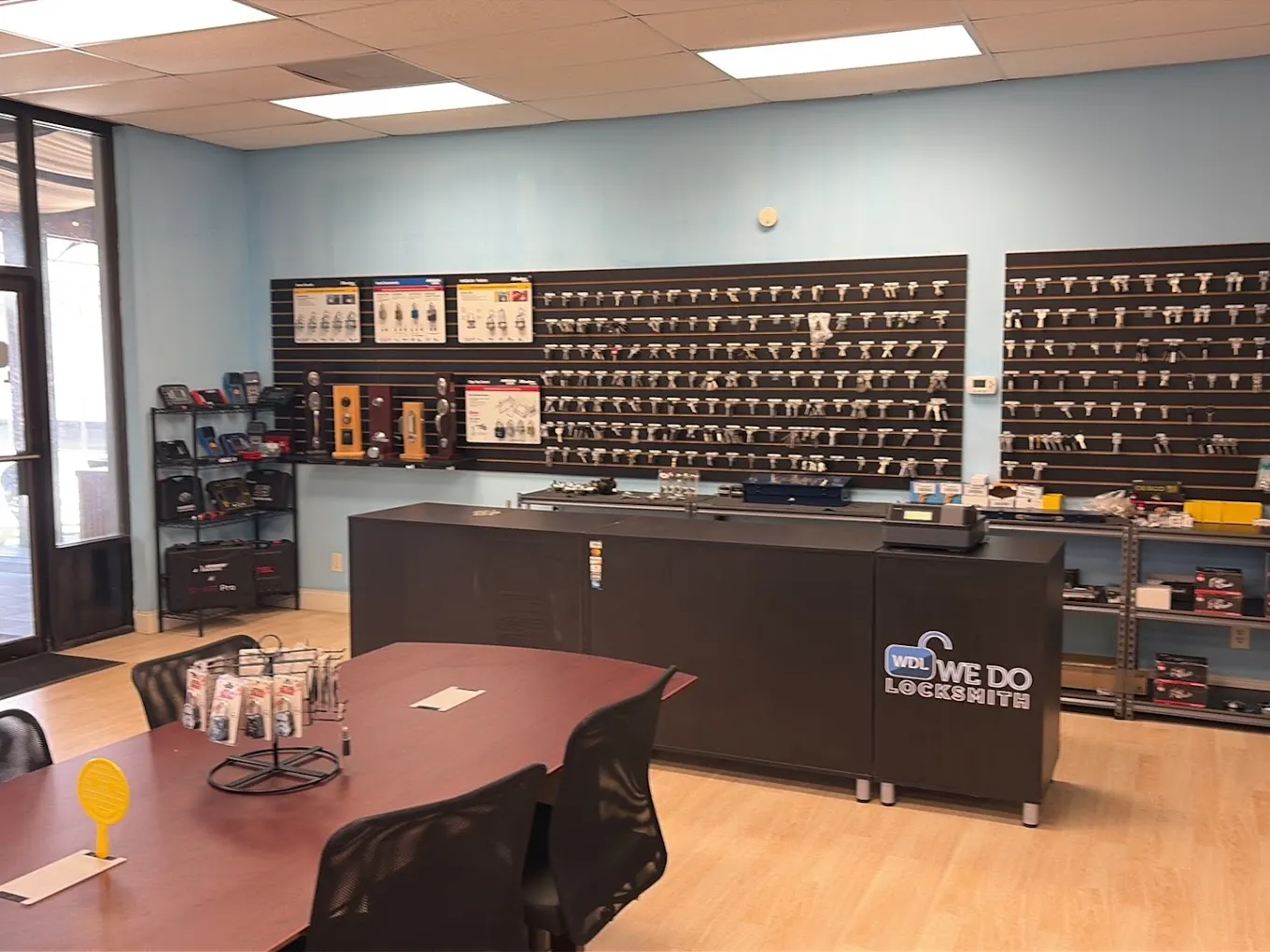 Inside the We Do Locksmith shop in Jacksonville: counter with the logo, meeting table and key wall